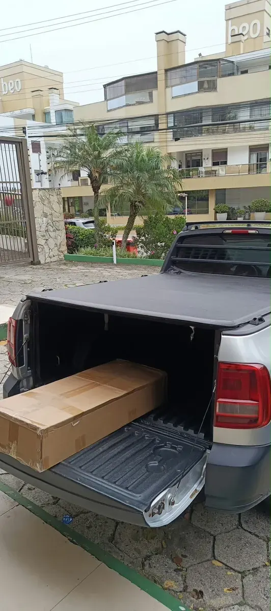 Móvel embalado sendo descarregado do utilitário em um condomínio